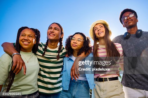 Group of teenager friends embracing and looking up at the sky Group of teenager friends embracing and looking up at the sky