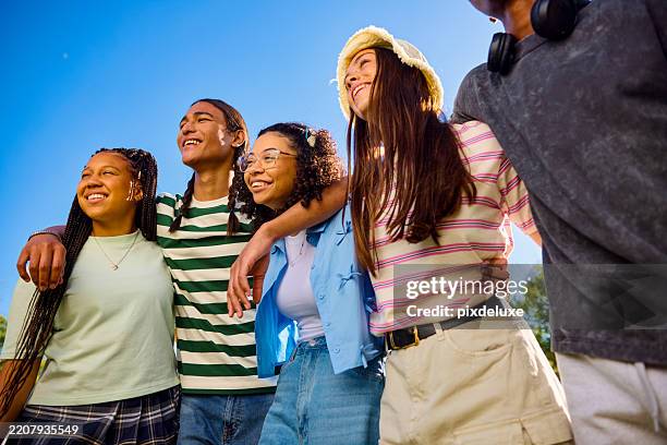 group of teenager friends embracing and looking up at the sky - looking up boys shorts stock pictures, royalty-free photos & images