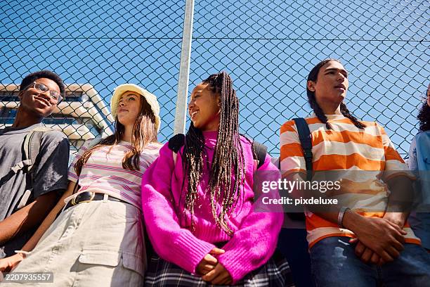 high school students chatting by the fence after school - alleen tieners stockfoto's en -beelden