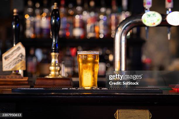 ein erfrischendes pint lagerbier auf der theke - kneipe stock-fotos und bilder