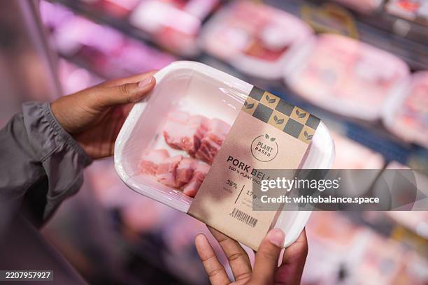 close-up shot of a man buying plant-based meat at the supermarket - alternative lifestyle stock pictures, royalty-free photos & images