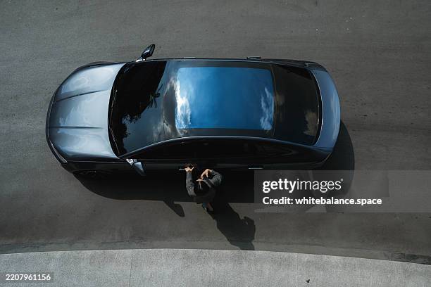 businesswoman entering ev car shared with her colleagues, ready for the commute to work - carsharing stock-fotos und bilder