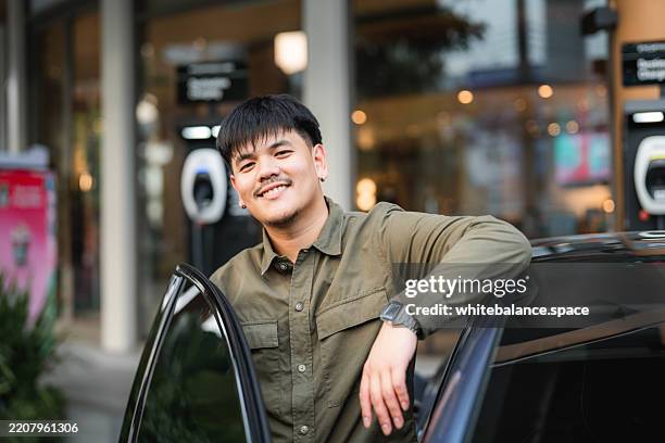 portrait of smiling driver standing by the open car door - hit the road saying stock pictures, royalty-free photos & images