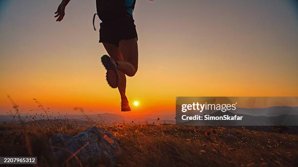 trail runner in motion on alpine ridge at sunset - cross country running stock pictures, royalty-free photos & images