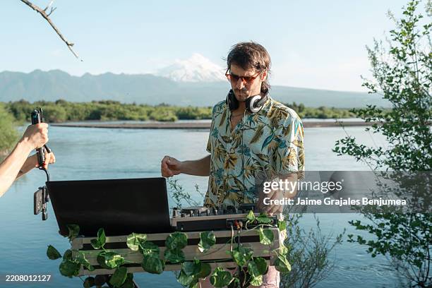 dj pinchando música en una fiesta en el río con el monte fuji de fondo - dj de club fotografías e imágenes de stock