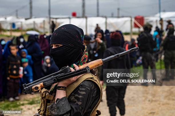 Woman fighter stands guard during a joint security operation for Syria's Kurdish Internal Security Police Force, also known as Asayesh, and the...