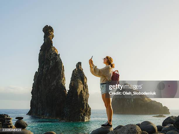 femme photographiant avec smartphone des vues épiques du bord de mer sur l’île de madère - escapade urbaine photos et images de collection