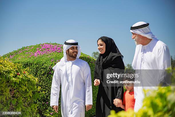 three generation arab family enjoying at park - emirati family stock pictures, royalty-free photos & images