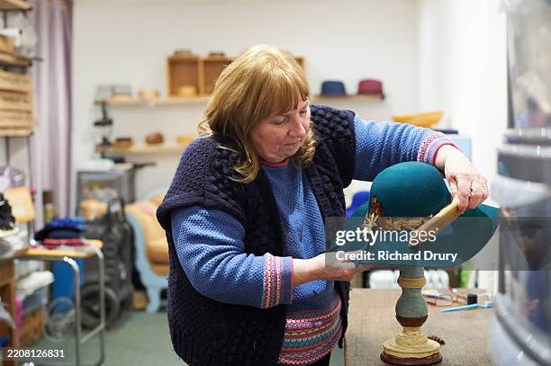milliner brushing a hat - hat maker stock pictures, royalty-free photos & images