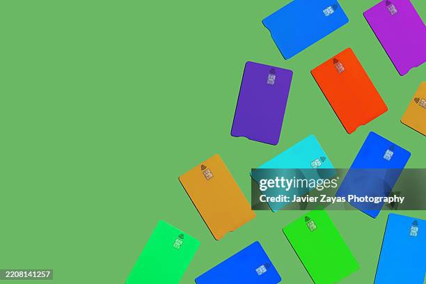 colorful credit cards lying on a green background - shopaholic stock pictures, royalty-free photos & images