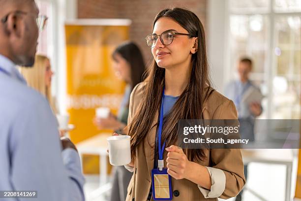 engaging discussions and networking at a business conference in a convention center - lanyard stock pictures, royalty-free photos & images