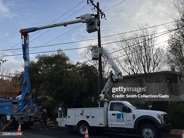 Utility crews using bucket lifts to work on power lines along Hough Avenue in Lafayette, California, March 28, 2025.