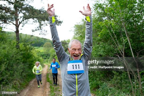 senior man celebrating his win after crossing the finish lin. - endurance stock pictures, royalty-free photos & images