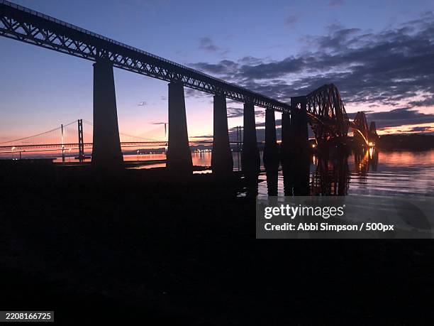 silhouette bridge over sea against sky during sunset,south queensferry,united kingdom,uk - cantilever stock pictures, royalty-free photos & images