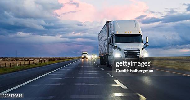 car pov of semi-trucks driving interstate 5 under beautiful clouds - lastbil bildbanksfoton och bilder