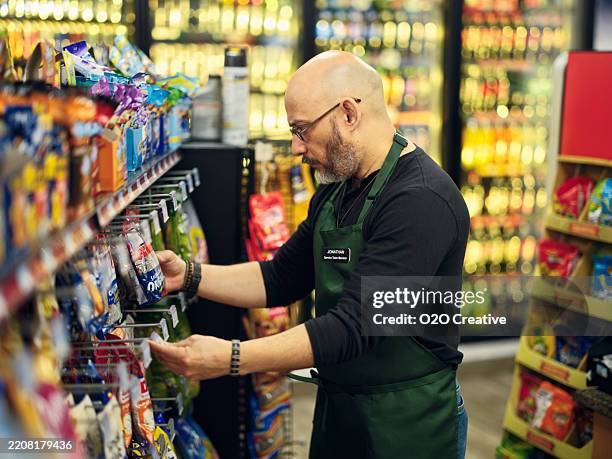 small business owner at work in his small convenience store - corner shop stock pictures, royalty-free photos & images