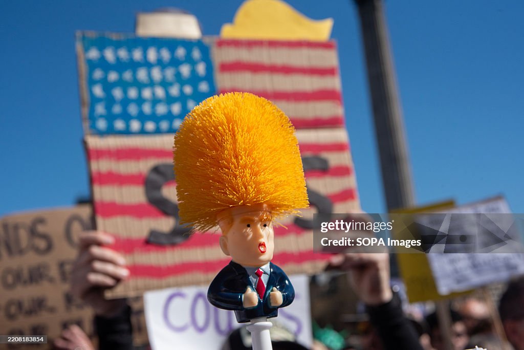 A protester holds a Donald Trump toilet brush during the '...