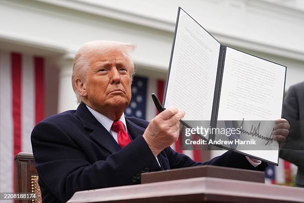 President Donald Trump displays a signed executive order imposing tariffs on imported goods during a “Make America Wealthy Again” trade announcement...