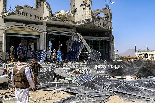 People inspect a heavily-damaged building used to store solar energy panels that was reportedly hit by a US air strike in Yemen's northern province...