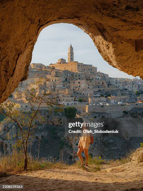 femme regardant le paysage urbain de la ville de matera depuis la grotte - canyon photos et images de collection