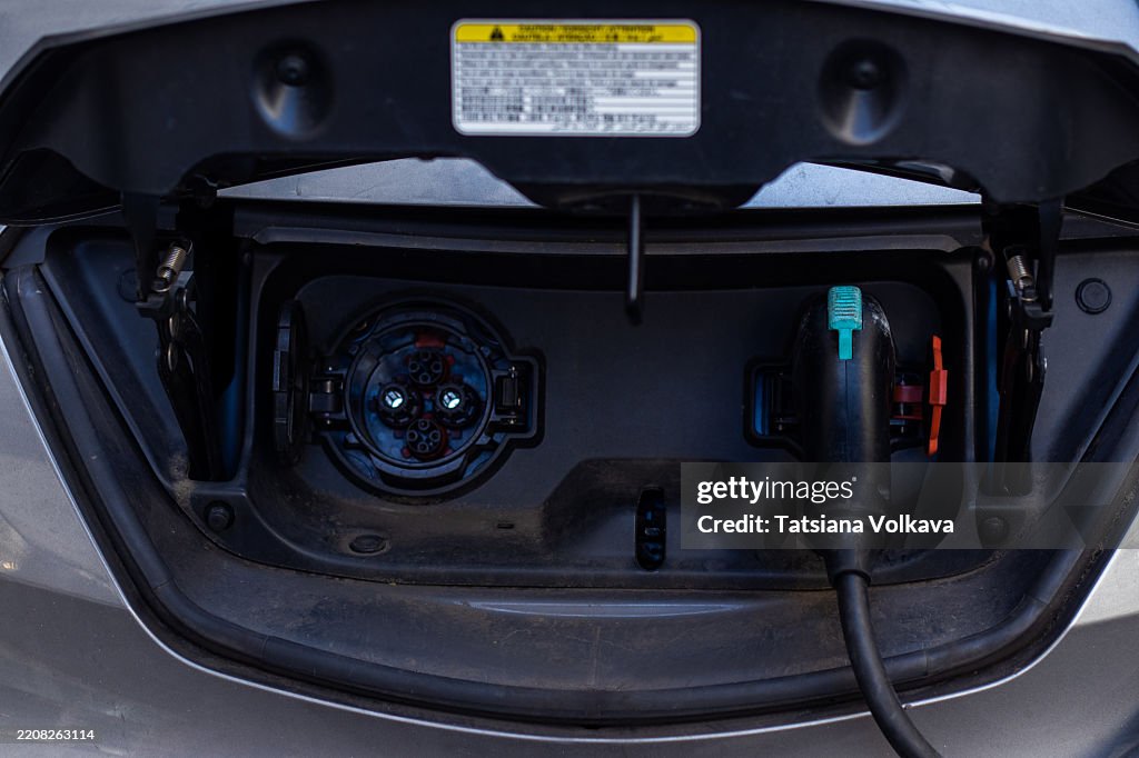 Electric Vehicle Charging Port with Plug Connected on Modern Car