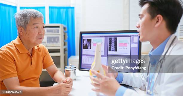 el médico explica los ligamentos de la rodilla - femur fotografías e imágenes de stock