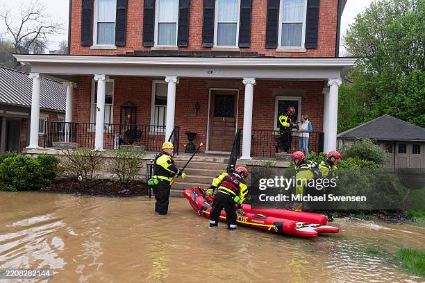 Firefighters from Winchester's Search and Rescue check on homeowners as the Kentucky River rises on April 6, 2025 in Frankfort, Kentucky. Frankfort...