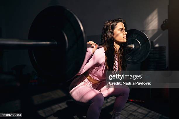 junge frau training in einem fitnessstudio - fitnesseinrichtung stock-fotos und bilder