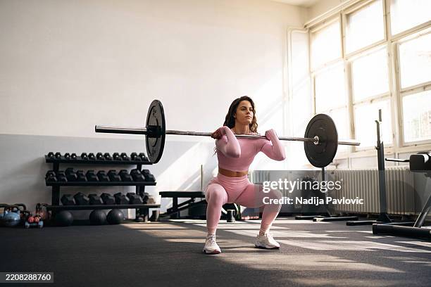 mujer joven haciendo ejercicios en el gimnasio. - ropa-ajustada fotografías e imágenes de stock