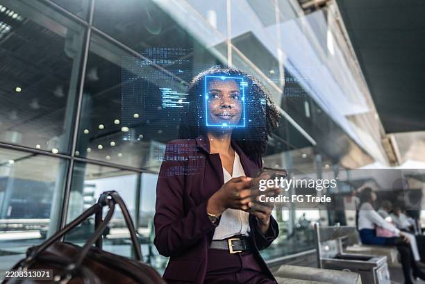 businesswoman using facial recognition technology on smartphone at airport - equipamento de exame médico por imagem de diagnóstico imagens e fotografias de stock