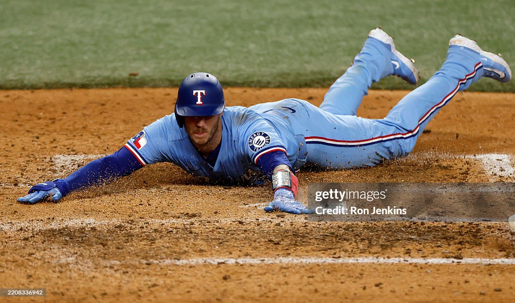 Texas Ranger Heim Jonah Heim of the Texas Rangers slides into home plate to score a run ...