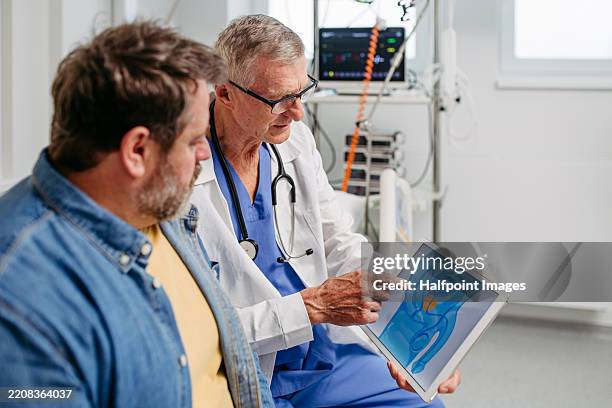 doctor explaining prostate examination to male patient. - sistema urinario fotografías e imágenes de stock