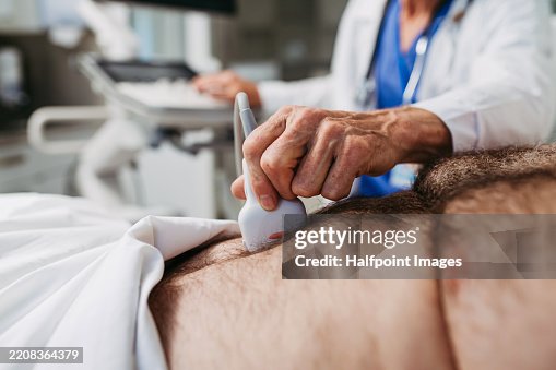 Close up of doctor performing an ultrasound on male patient's abdomen Close up of doctor performing an ultrasound on male patient's abdomen