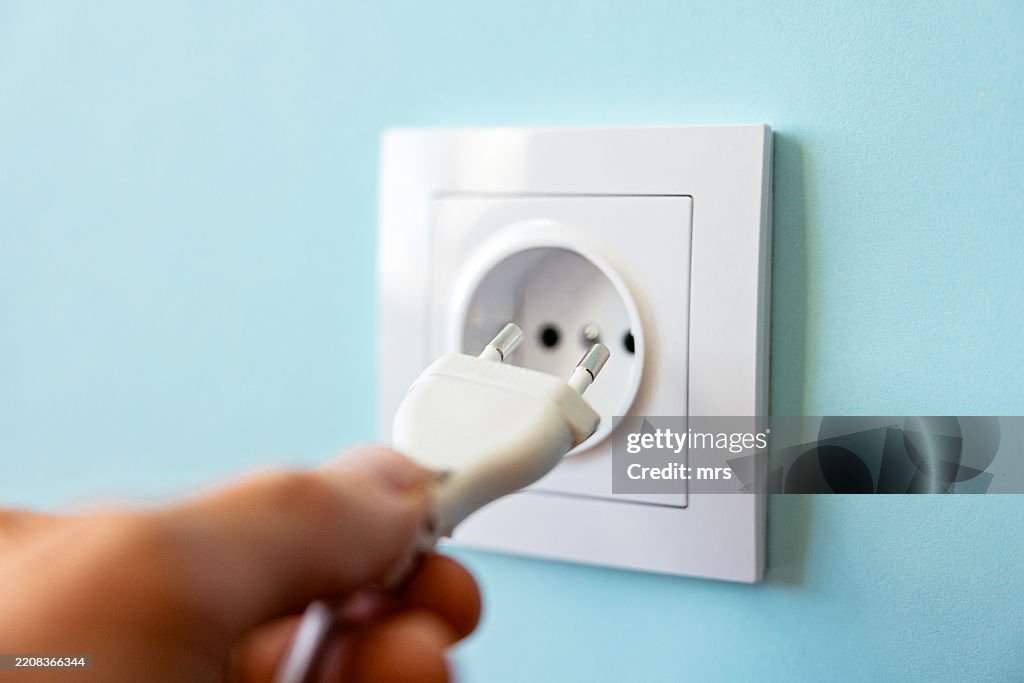 Plugging cable into plug socket