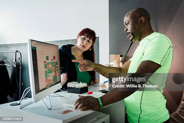 fitness trainer assisting client with scheduling at ems gym - beard goatee styles stock pictures, royalty-free photos & images