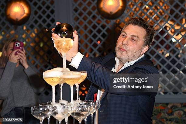Mikhail Gokhner pouring champagne into a glass tower at the Osteria Del Mare Launch Party on April 03, 2025 in London, England.