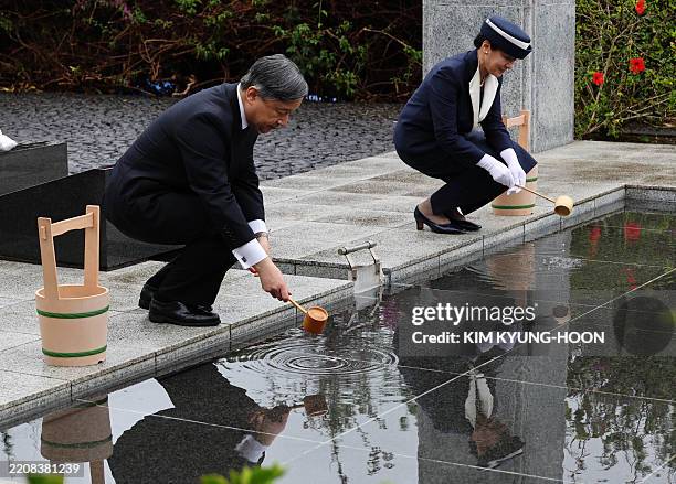 Japan's Emperor Naruhito and Empress Masako pour water on requiem hill as they visit the island of Iwo Jima, which is now officially called Ioto, on...