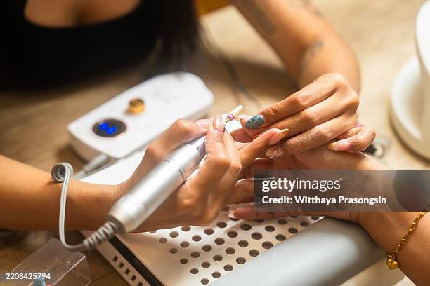 close-up of professional manicure procedure in beauty salon - gel pack stock pictures, royalty-free photos & images