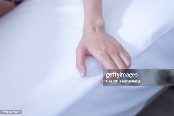 people relaxing on the hotel bed - hand clutching sheet stock pictures, royalty-free photos & images