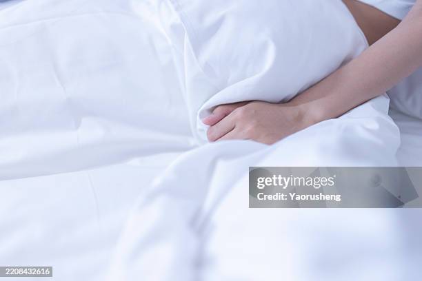 people relaxing on the hotel bed - hand clutching sheet stock pictures, royalty-free photos & images