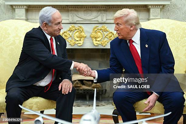 President Donald Trump shakes hands with Israeli Prime Minister Benjamin Netanyahu during a meeting in the Oval Office of the White House in...