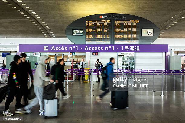 Passengers in motion blur passing the Air France check-in area at Roissy Charles de Gaulle airport in Paris in France on March 29, 2025.