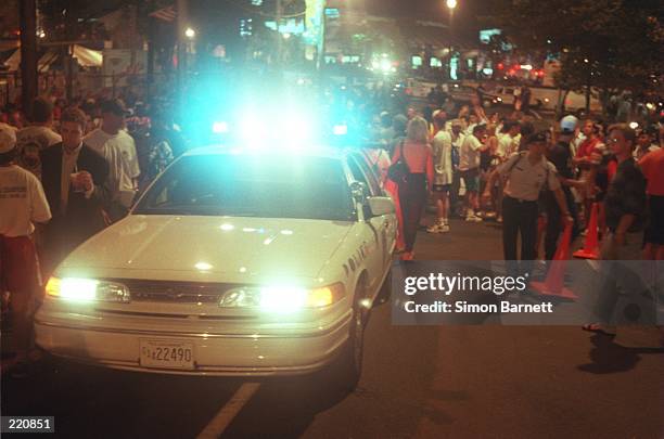 Police car assists in clearing the crowd shortly after an explosion, suspected to be a bomb, at the AT&T Pavillion in Centennial Park during the 1996...