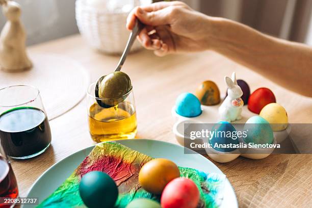 man's hand painting easter eggs - ostersonntag stock-fotos und bilder