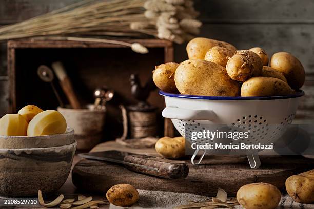 potatoes in colander on kitchen counter - pomme de terre photos et images de collection
