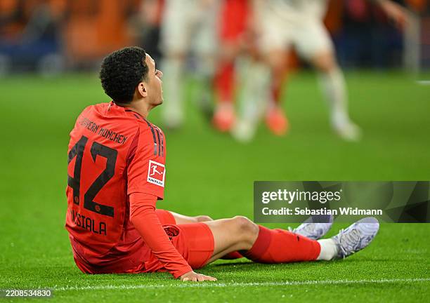 Jamal Musiala of Bayern Munich goes down with an injury during the Bundesliga match between FC Augsburg and FC Bayern München at WWK-Arena on April...