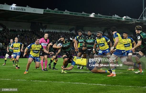 Juarno Augustus of Northampton Saints breaks through to later score a try during the Investec Champions Cup Round of 16 match between Northampton...