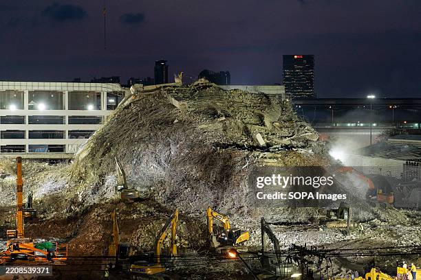 Heavy machinery clears the huge pile of concrete of a building that collapsed after an earthquake in Bangkok. The search operation for bodies,...