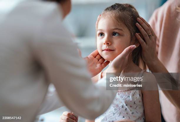 examen de l’enfant avec un pédiatre et une mère dans une clinique lumineuse - pédiatre photos et images de collection