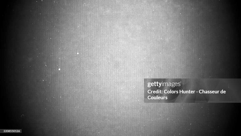 Textured gray background with a halo light. Close-up of a dirty and dusty LED TV screen.